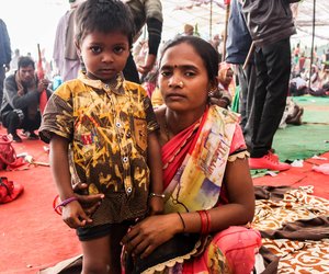 Child with mother sitting under the canopy at Ramleela maidan