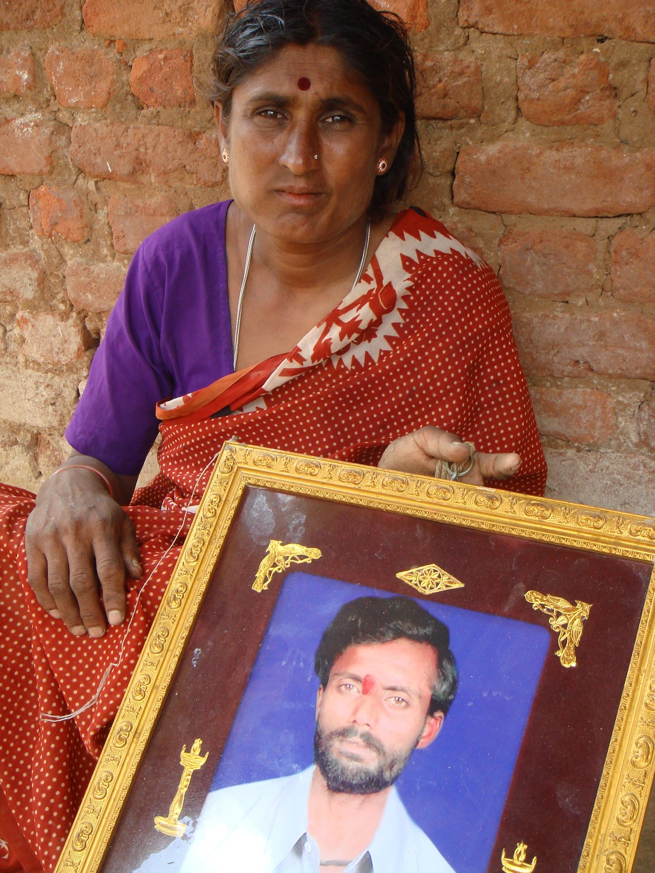 Jayalakshmamma holding the photo of her deceased husband