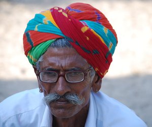 A man with a colourful head gear