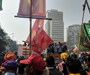 From the back of a truck, photographers and reporters record the march.
