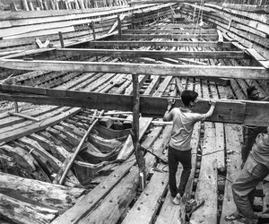 Men relaxing on a partially built ship