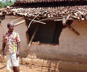 Man standing in front of dilapidated hut