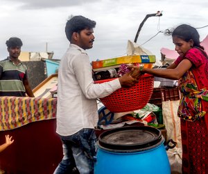 P. Jagadeesh and his pregnant wife, P. Mabbi, trying to salvage their belongings from the rubble